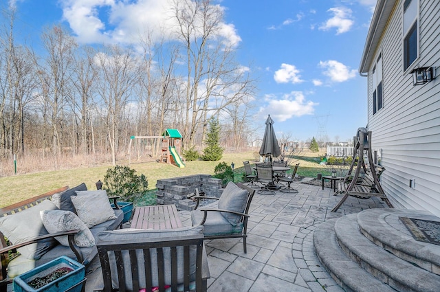 view of patio / terrace featuring outdoor dining space, a playground, and an outdoor living space with a fire pit