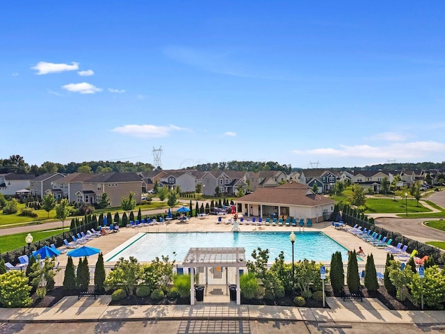 pool featuring a residential view, a patio, and fence