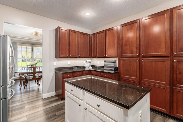6148 Ryan Woods Way, Hilliard, OH 43026 - kitchen with white cabinets, freestanding refrigerator, baseboards, a textured ceiling, and dark wood-style flooring