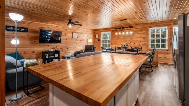 interior space featuring dark wood-type flooring, wooden ceiling, and a ceiling fan