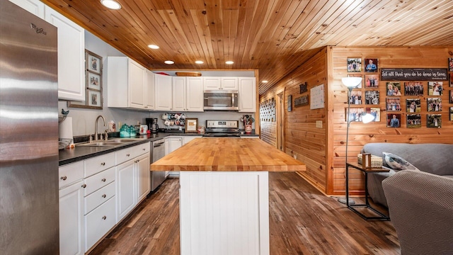 kitchen featuring wooden counters, a sink, stainless steel appliances, white cabinets, and wooden ceiling