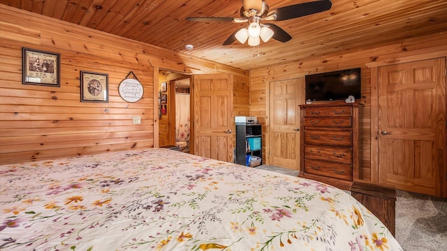 bedroom with wooden ceiling, a ceiling fan, and wood walls