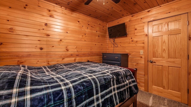 bedroom with carpet floors, wooden walls, wooden ceiling, and a ceiling fan