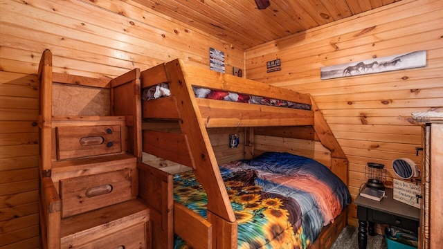 bedroom featuring wooden ceiling and wooden walls