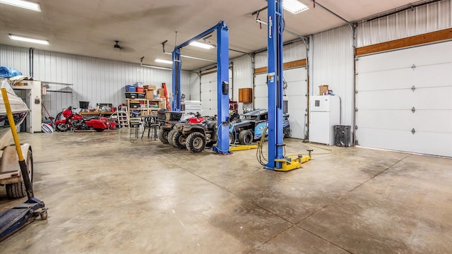 garage featuring metal wall and freestanding refrigerator