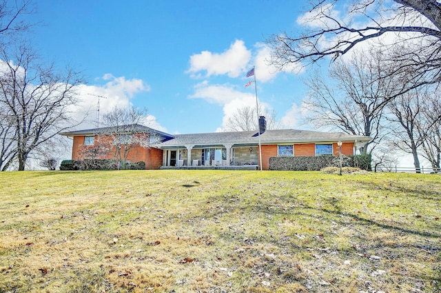 view of front of home featuring brick siding and a front yard