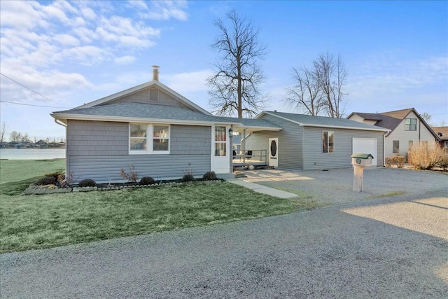 view of front of property featuring a front lawn, a garage, and aphalt driveway