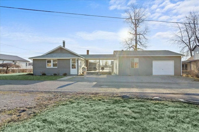 view of front of property featuring driveway, an attached garage, and a front lawn