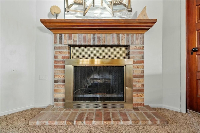 details featuring baseboards, carpet, and a brick fireplace