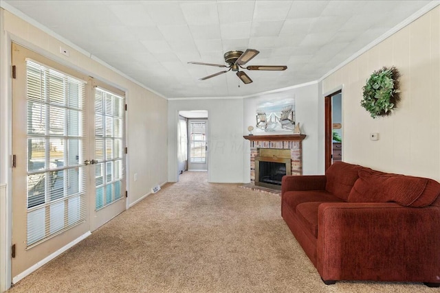 living area with ceiling fan, a brick fireplace, light carpet, and ornamental molding