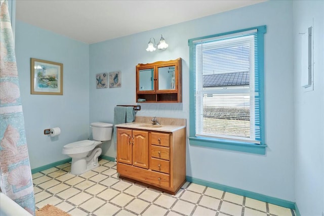 bathroom with tile patterned floors, baseboards, toilet, and vanity