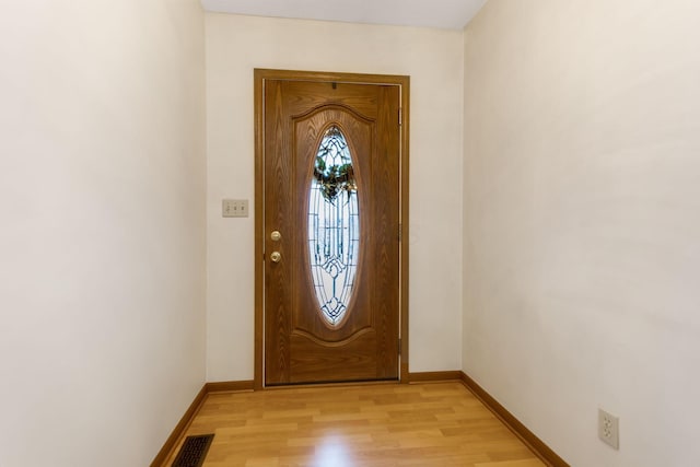 foyer entrance with visible vents, baseboards, and light wood finished floors