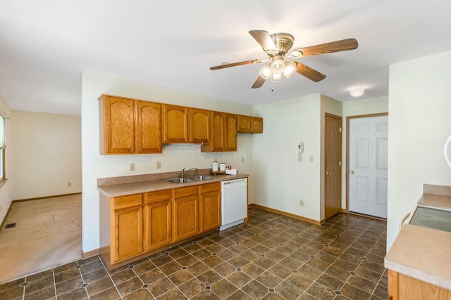 kitchen with baseboards, light countertops, brown cabinets, white dishwasher, and a sink