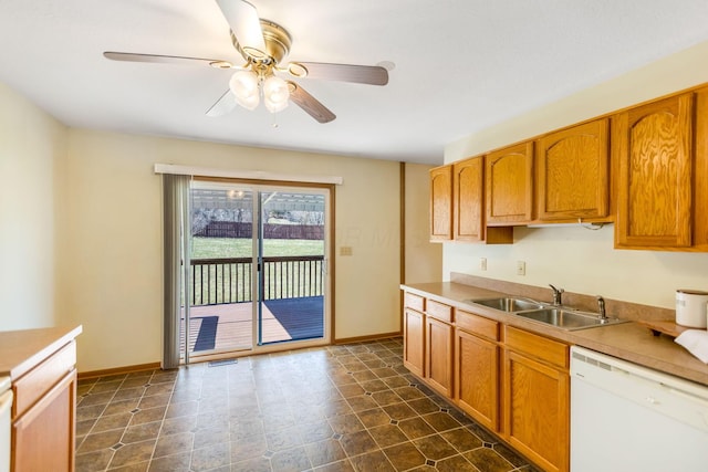 kitchen with brown cabinets, a sink, light countertops, dishwasher, and ceiling fan