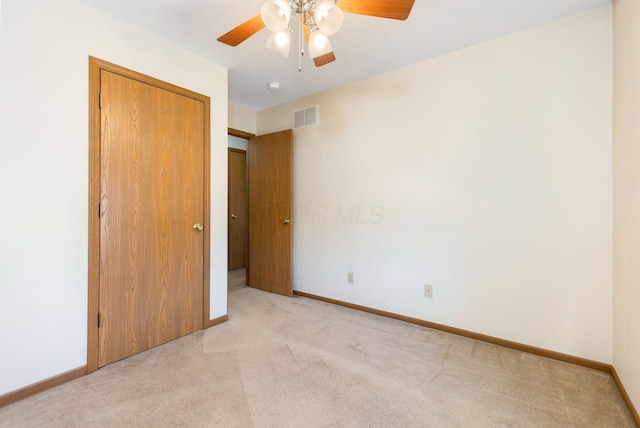 unfurnished bedroom with light carpet, visible vents, a closet, and baseboards