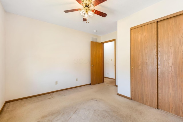 unfurnished bedroom featuring visible vents, baseboards, light colored carpet, and a closet