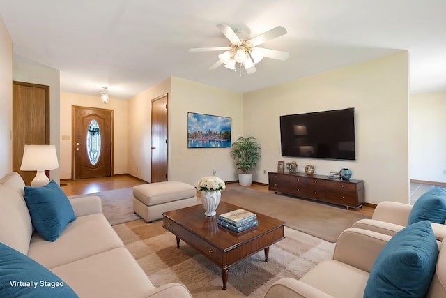 living room with baseboards, light wood-style floors, and a ceiling fan