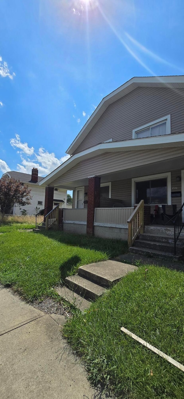 exterior space featuring covered porch and a yard