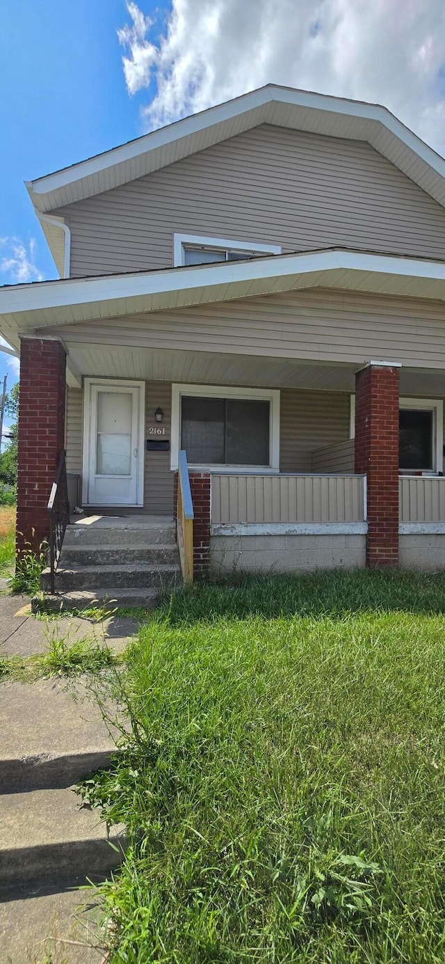 view of front of property featuring covered porch and a front lawn