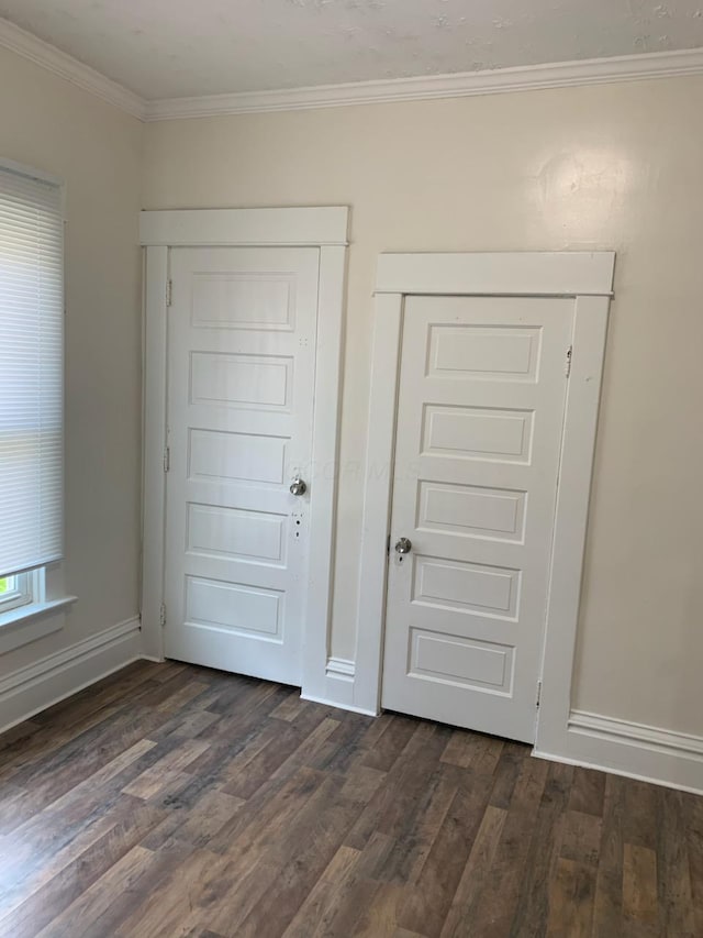 unfurnished bedroom featuring dark wood finished floors, baseboards, a closet, and ornamental molding