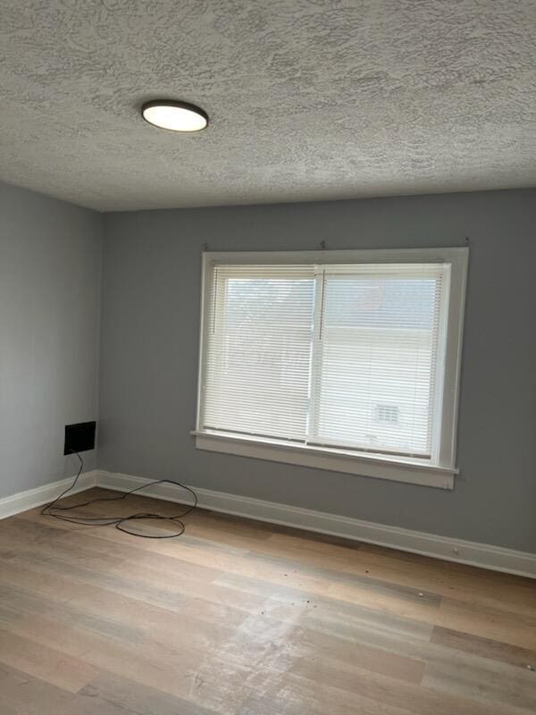 empty room featuring wood finished floors and baseboards