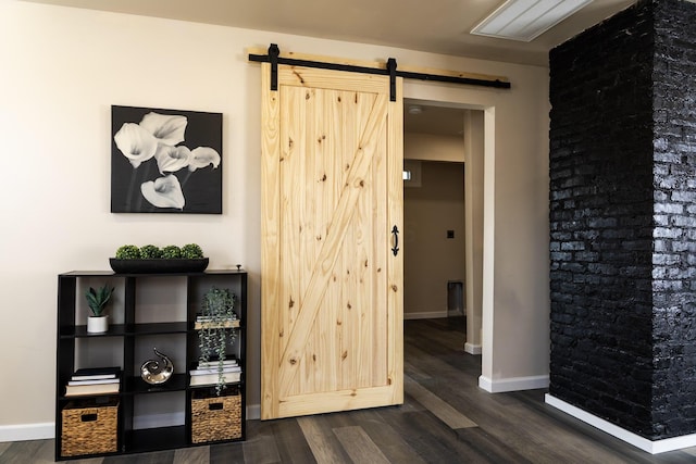 interior space featuring a barn door, baseboards, and dark wood-style flooring