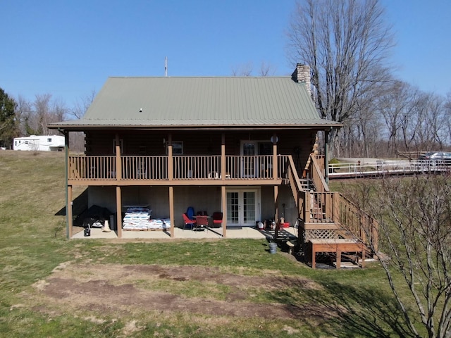 back of house with french doors, a patio, metal roof, and a chimney