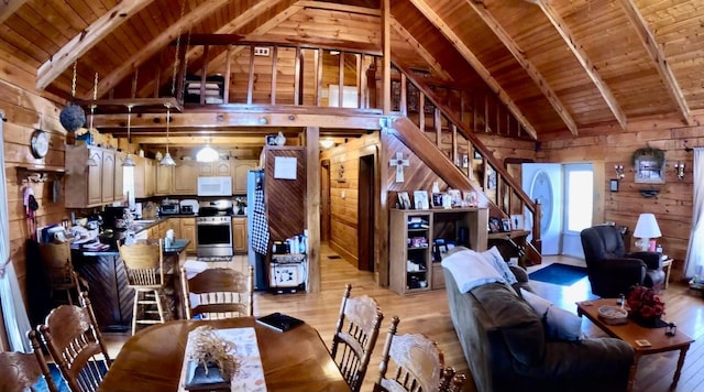 dining space featuring stairs, light wood-style flooring, wood walls, and wooden ceiling