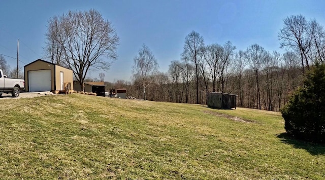 view of yard with a garage and an outbuilding