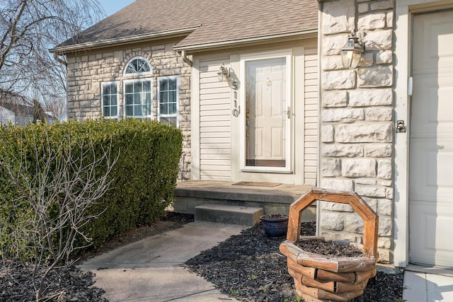 property entrance featuring stone siding and roof with shingles