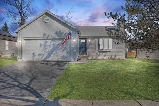 ranch-style house with a lawn, driveway, a shingled roof, a garage, and a chimney