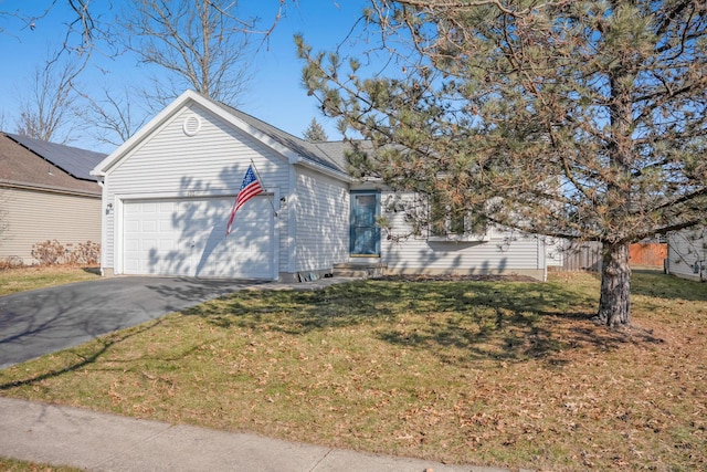 single story home featuring entry steps, a front lawn, a garage, and driveway