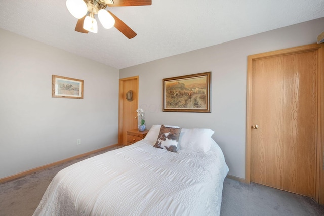 bedroom featuring baseboards, light carpet, a textured ceiling, and a ceiling fan