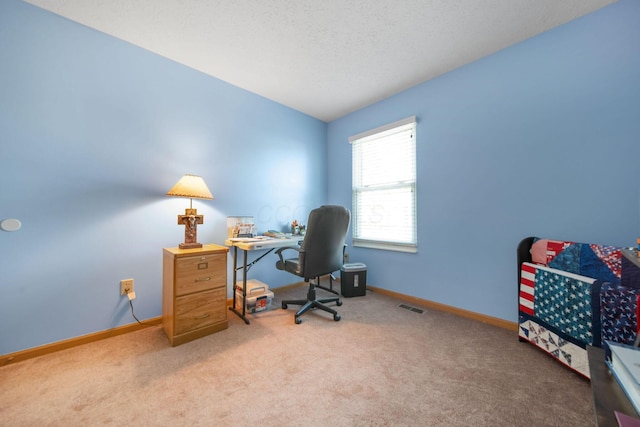 carpeted office space featuring baseboards, visible vents, and a textured ceiling