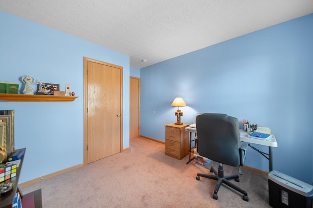 carpeted home office with a textured ceiling and baseboards