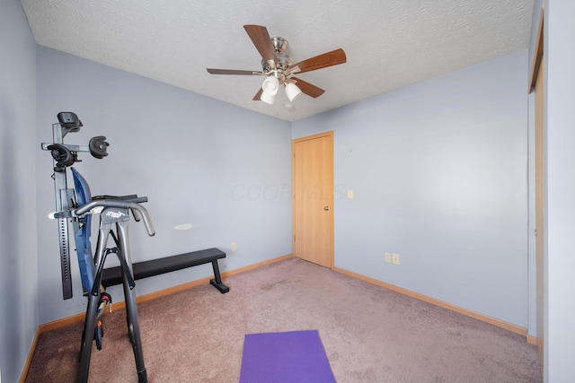 exercise area with baseboards, a textured ceiling, a ceiling fan, and carpet floors