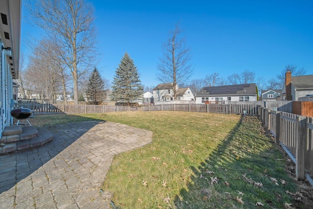 view of yard with a patio, a fenced backyard, and a residential view