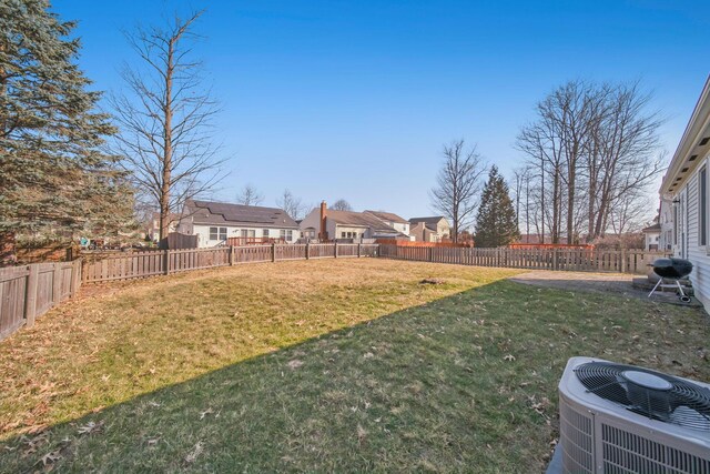 view of yard with cooling unit, a fenced backyard, and a residential view