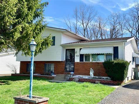 tri-level home featuring a front yard and brick siding