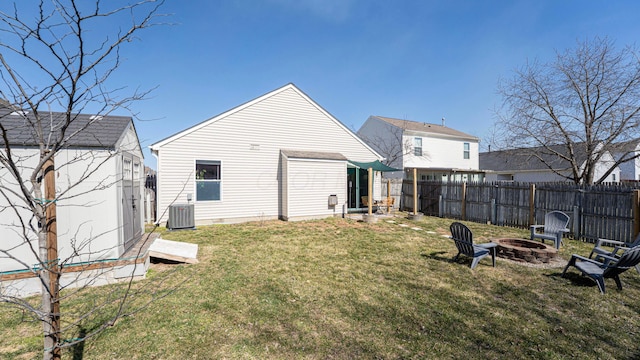 exterior space with a fire pit, central air condition unit, fence private yard, a yard, and an outdoor structure