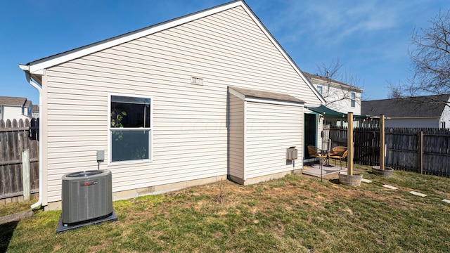 rear view of house with a lawn, central AC, and fence