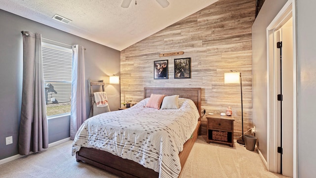 carpeted bedroom featuring visible vents, vaulted ceiling, wood walls, a textured ceiling, and an accent wall