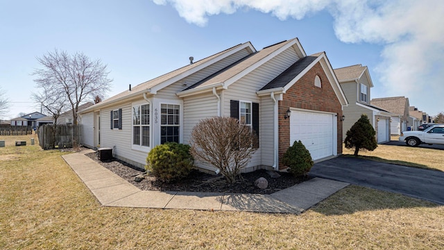 view of property exterior with an attached garage, fence, central air condition unit, a lawn, and driveway