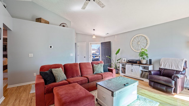 living room featuring vaulted ceiling, light wood-style floors, baseboards, and ceiling fan