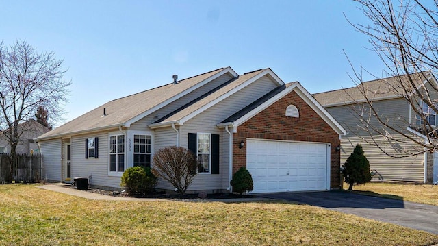 view of front of property with aphalt driveway, a front lawn, a garage, and brick siding