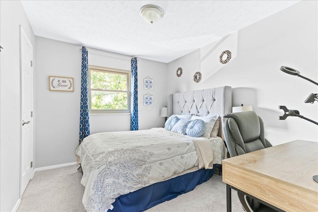 bedroom with a textured ceiling, light carpet, and baseboards