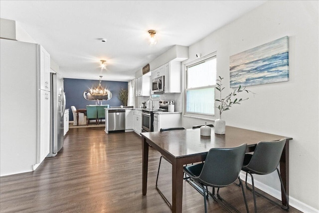 dining space featuring an inviting chandelier, dark wood-type flooring, and baseboards