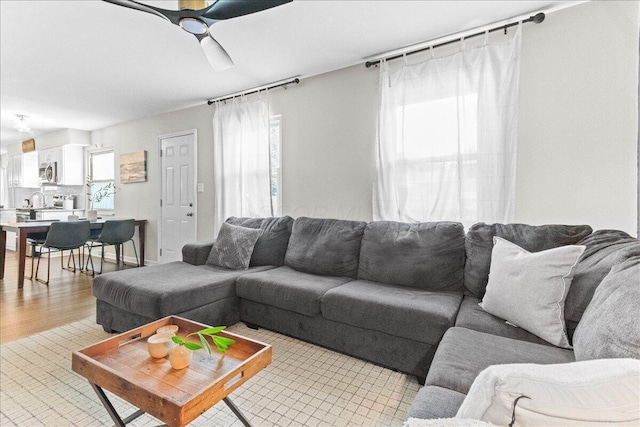 living area featuring a ceiling fan and light wood-style flooring