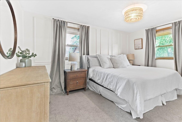 bedroom with light colored carpet and a decorative wall
