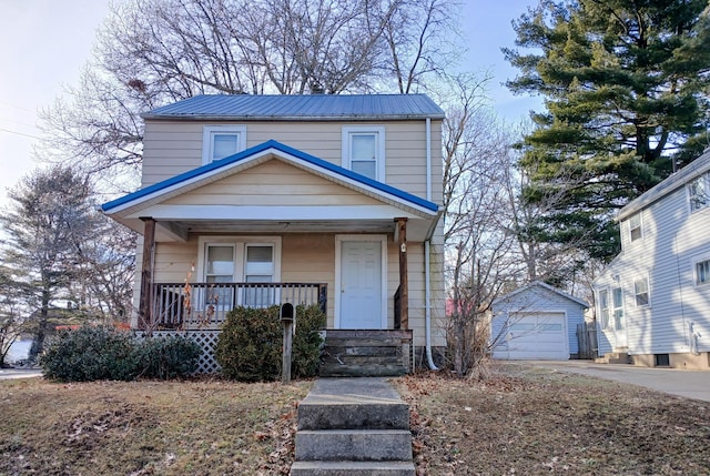 view of front of property featuring an outbuilding, a garage, covered porch, concrete driveway, and metal roof